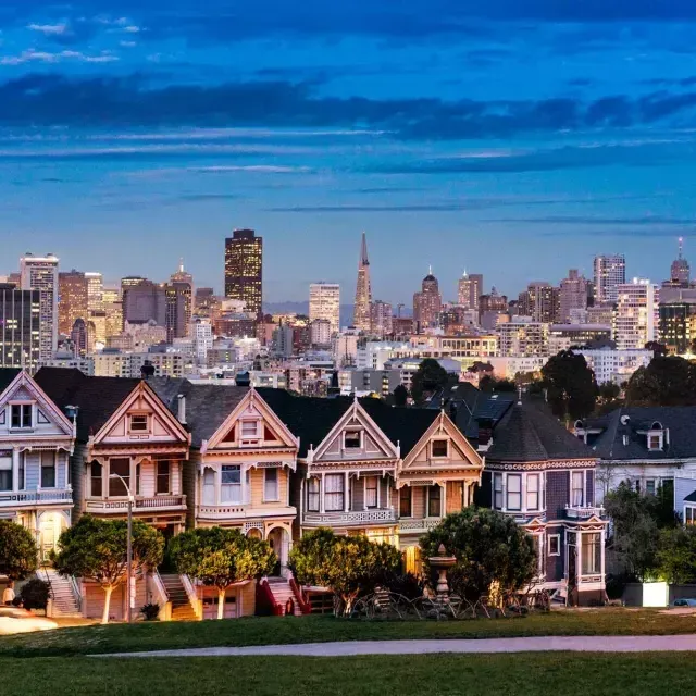 The famous 涂女士 of Alamo Square are pictured before the 贝博体彩app skyline at twilight.